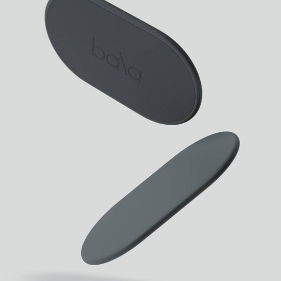 Two black oval objects with 'bala' branding on a light gray background