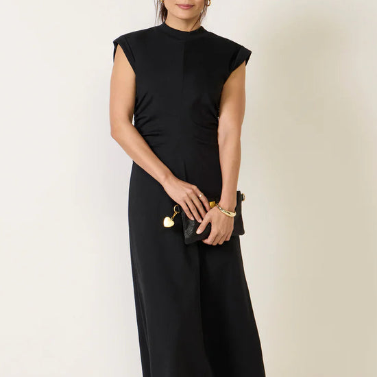 Woman wearing a black dress against a plain background