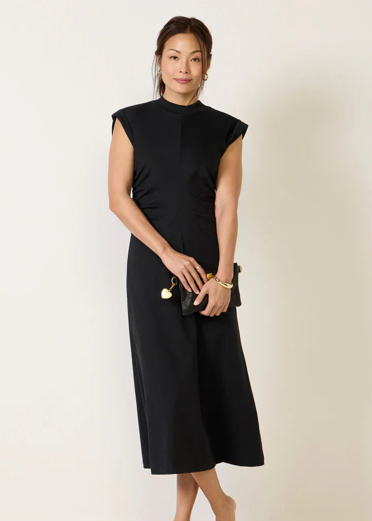 Woman wearing a black dress against a plain background