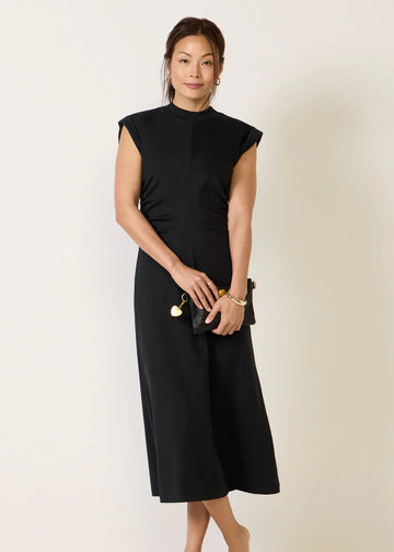 Woman wearing a black dress against a plain background