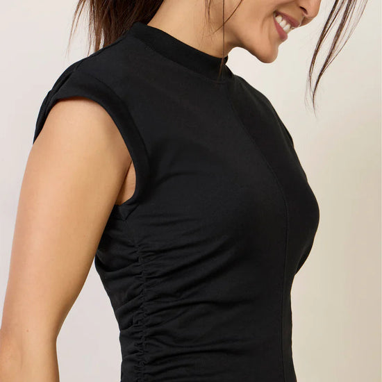 Woman wearing a black dress with a plain background
