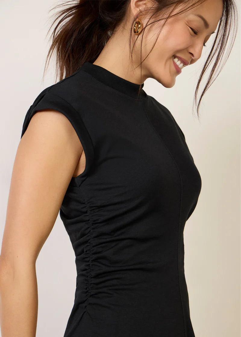 Woman wearing a black dress with a plain background