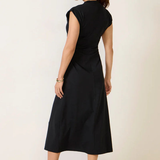 Woman wearing a black dress against a white background