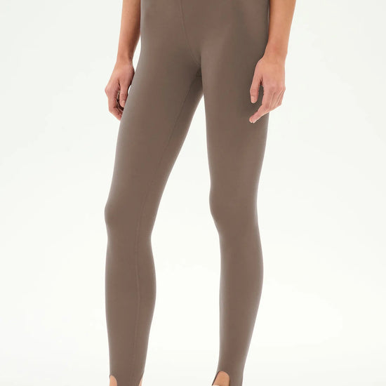 high-waisted taupe-brown stirrup leggings with a black dual waistband,