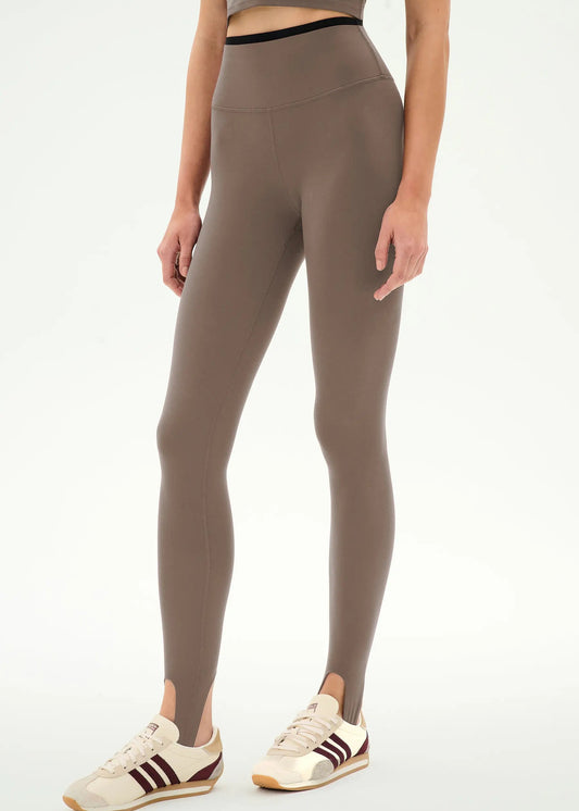 high-waisted taupe-brown stirrup leggings with a black dual waistband,