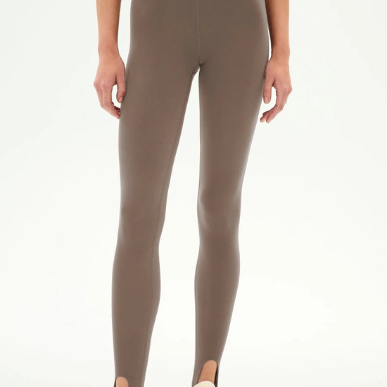 high-waisted taupe-brown stirrup leggings with a black dual waistband,