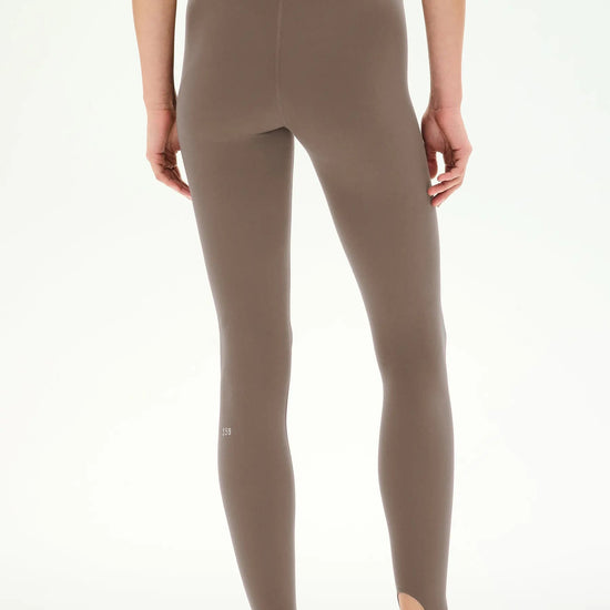 high-waisted taupe-brown stirrup leggings with a black dual waistband,