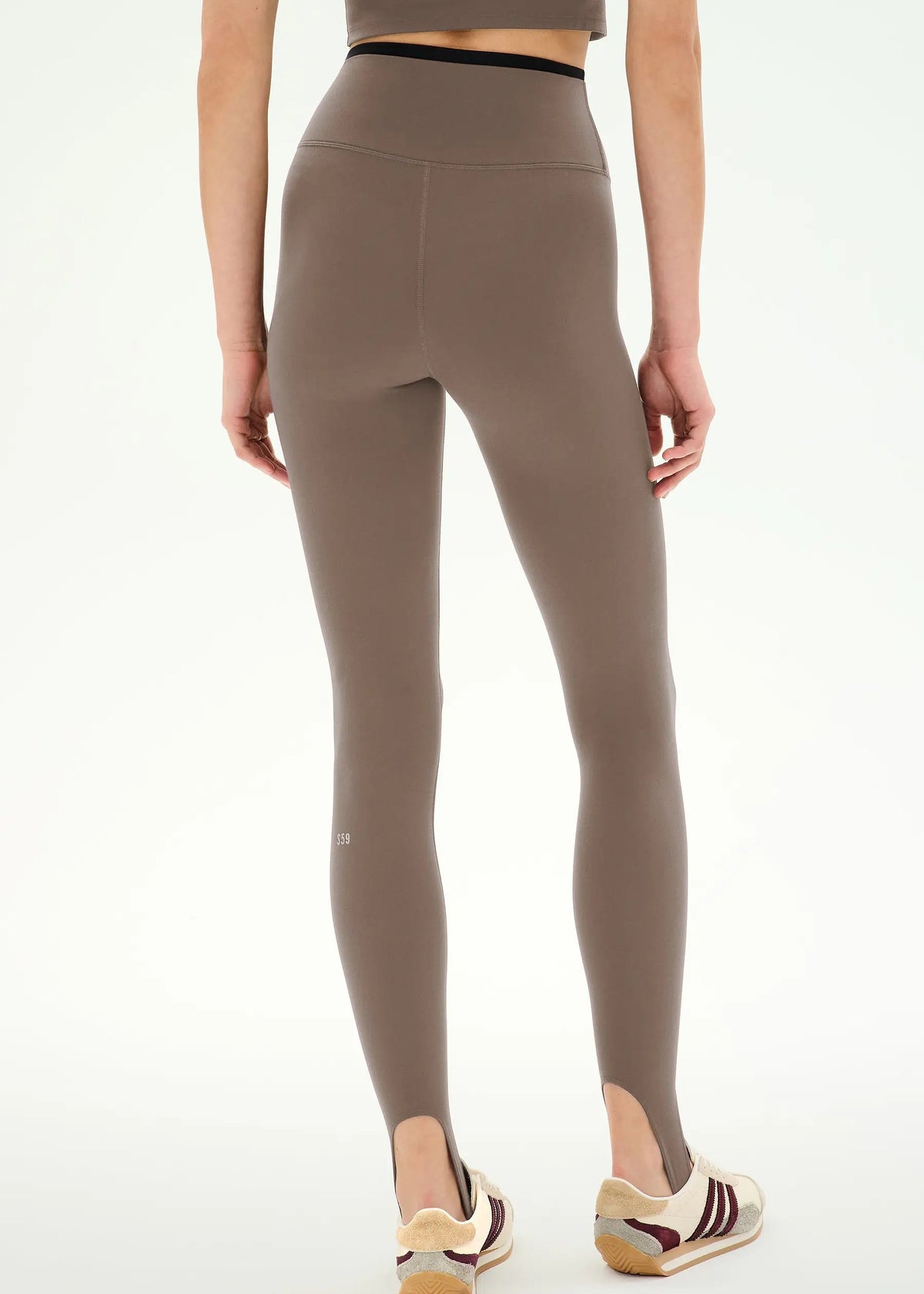 high-waisted taupe-brown stirrup leggings with a black dual waistband,