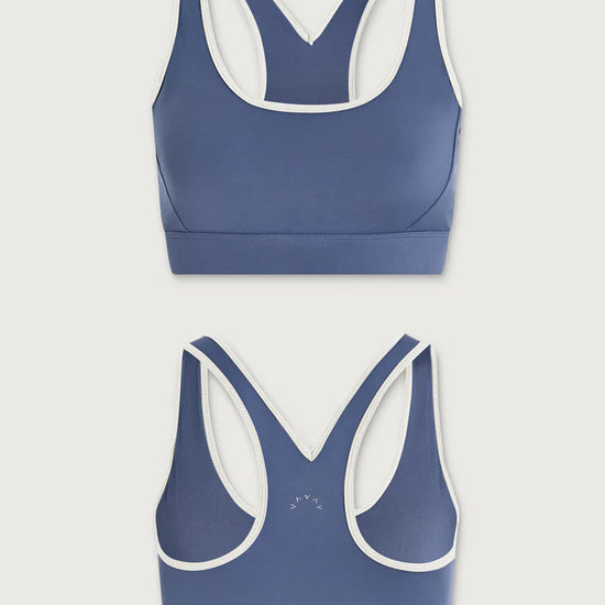 Two blue sports bras with white trim on a light gray background