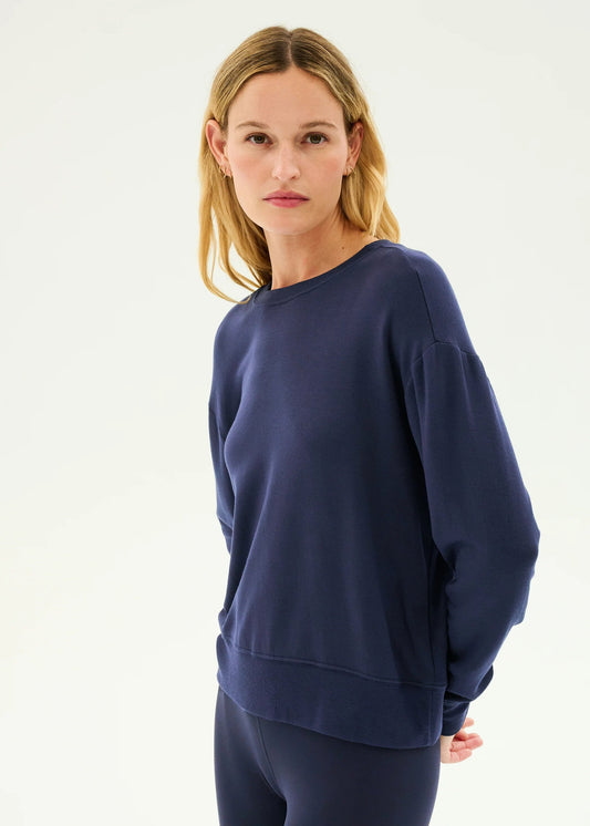 Woman wearing a navy blue sweatshirt and pants on a white background