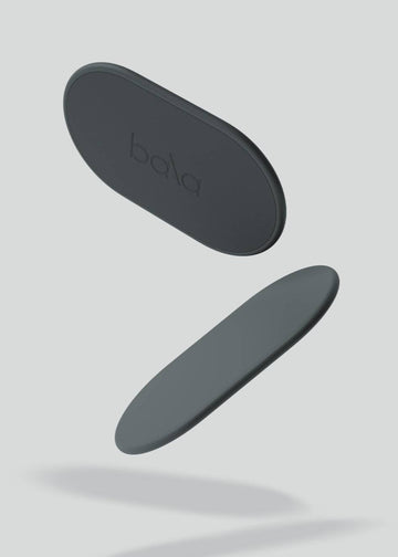 Two black oval objects with 'bala' branding on a light gray background