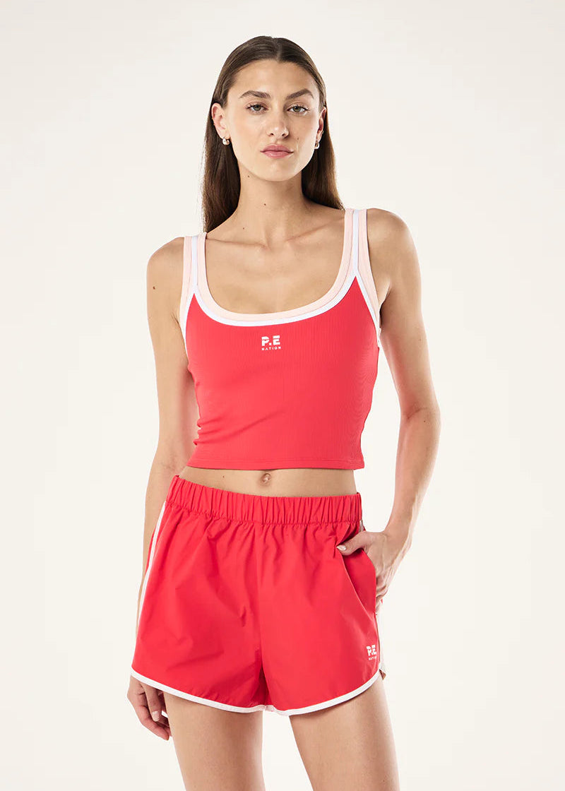 Woman wearing a red athletic outfit with a white logo on a light gray background