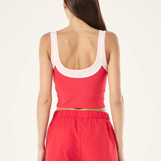 Woman wearing a red tank top and shorts set on a white background