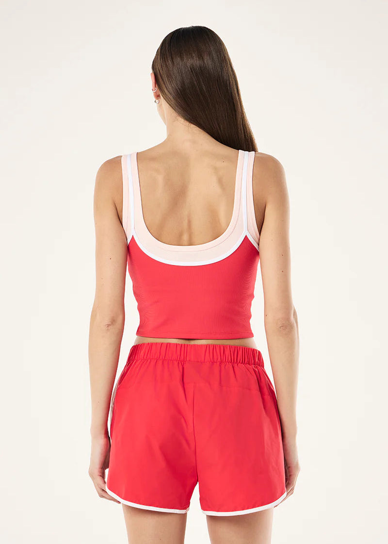 Woman wearing a red tank top and shorts set on a white background