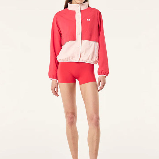 Person wearing a red and white tracksuit on a light gray background