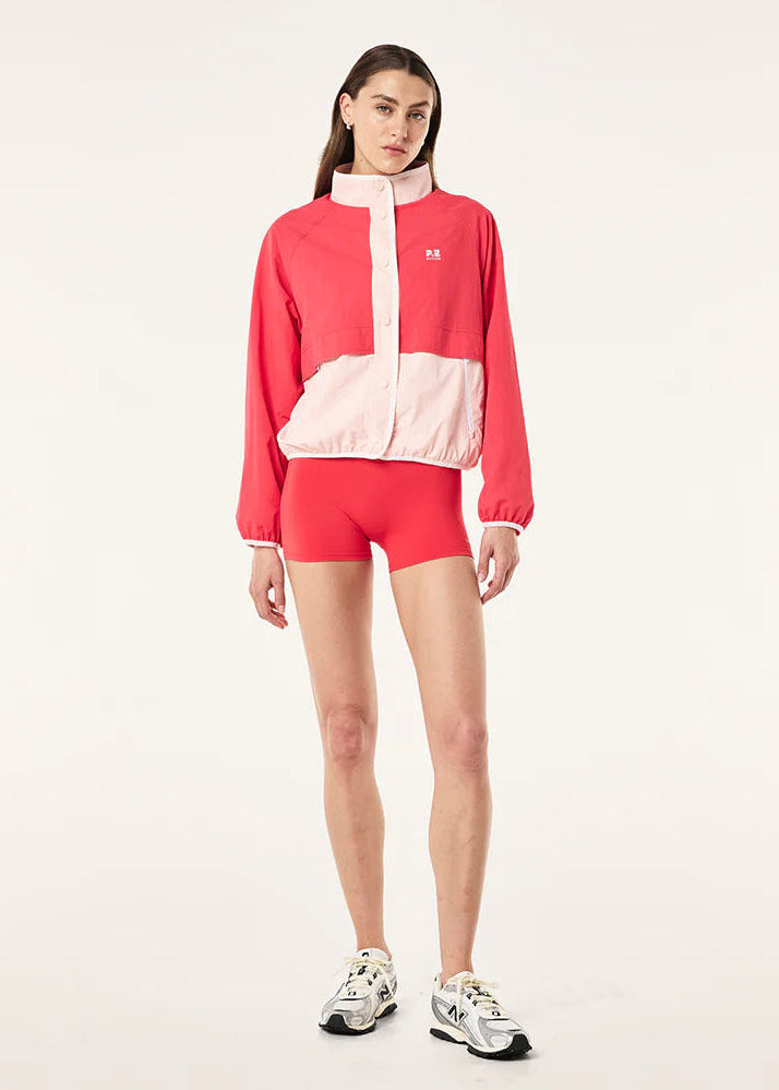 Person wearing a red and white tracksuit on a light gray background