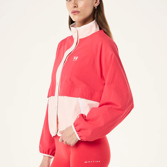 Woman wearing a red and white jacket with matching shorts on a white background