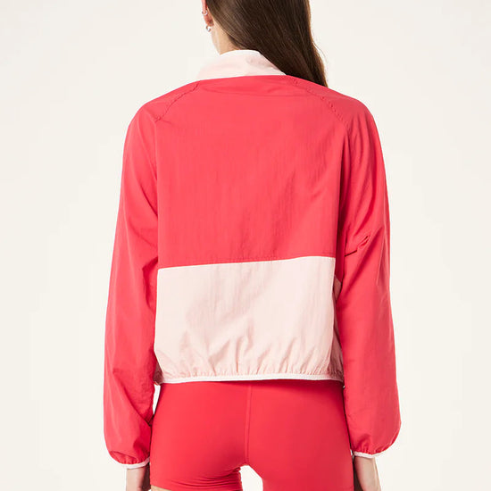 Woman wearing a two-tone pink jacket and shorts on a white background