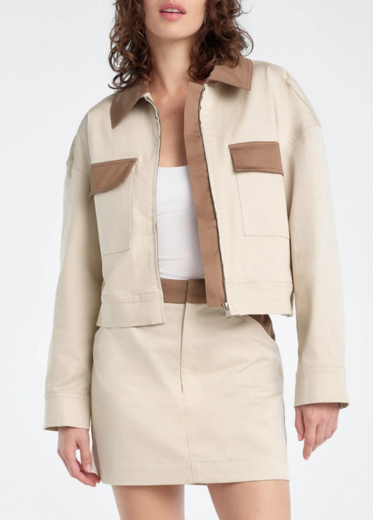 Woman wearing a beige and brown jacket with matching skirt on a white background