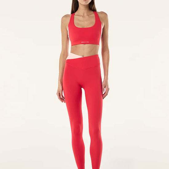 Woman wearing a red athletic outfit on a white background