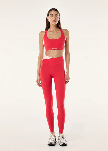 Woman wearing a red athletic outfit on a white background