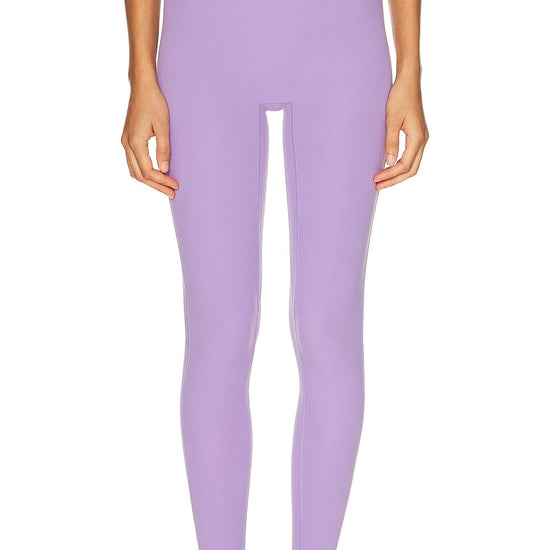Person wearing lavender leggings on a white background