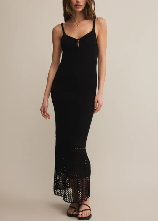 Woman wearing a black slip dress with lace hem on a beige background