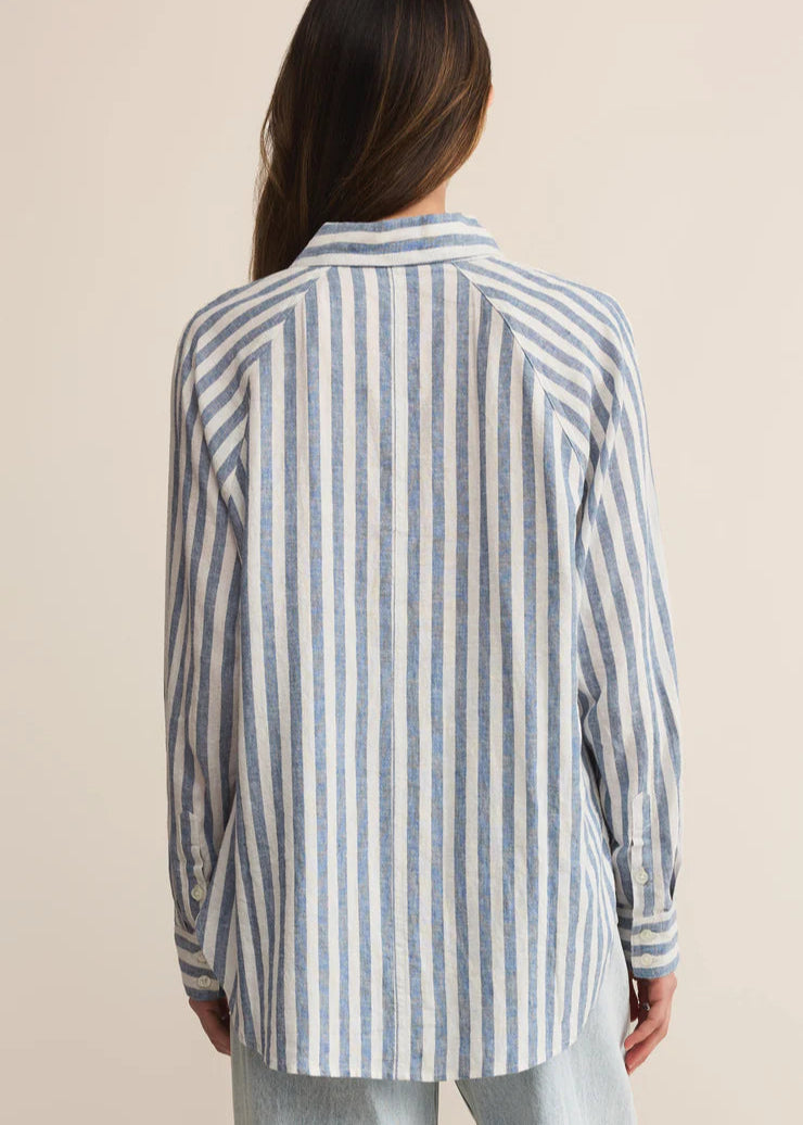 Person wearing a striped shirt from behind on a beige background
