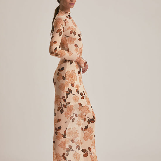 Woman wearing a floral dress against a plain background