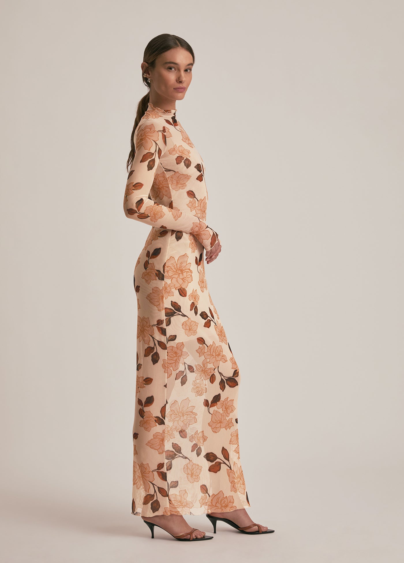 Woman wearing a floral dress against a plain background