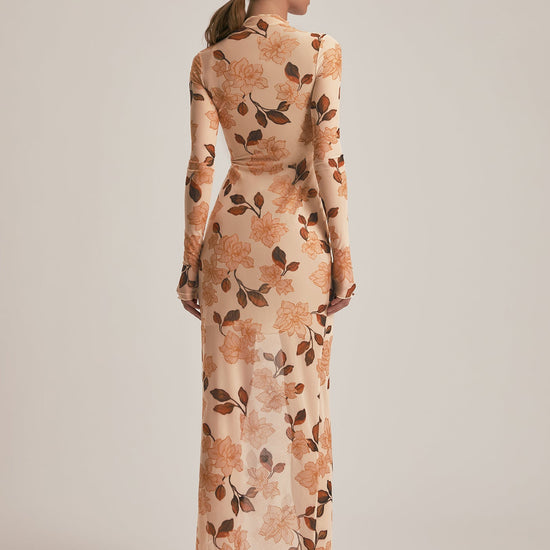 Woman wearing a floral dress with long sleeves on a plain background