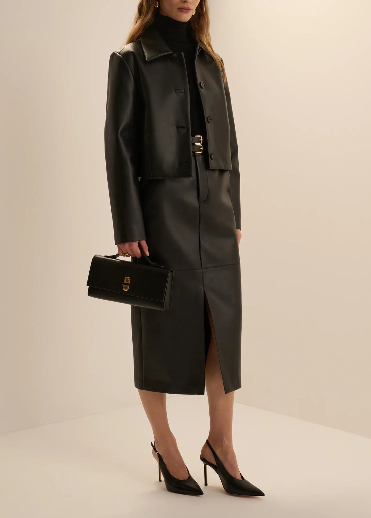 Women’s black leather cropped button-front jacket and midi pencil skirt with front slit, available at Ekam boutique Newport Beach