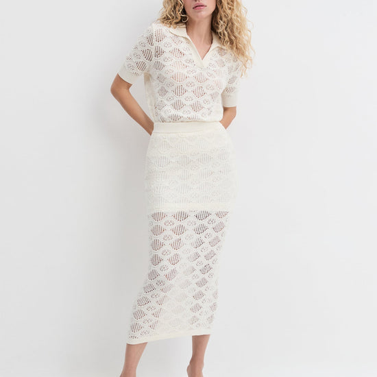 Woman wearing a white lace outfit on a plain background