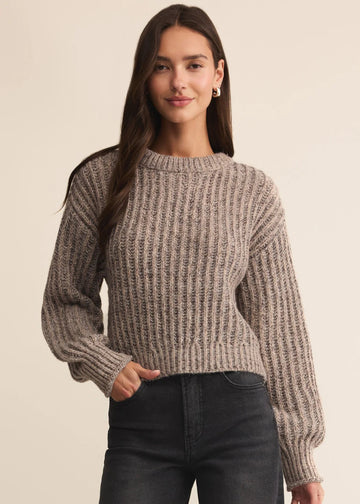 Woman wearing a brown knitted sweater against a beige background