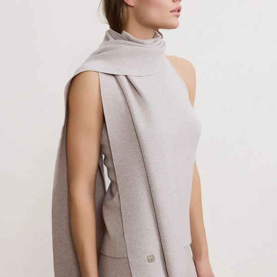 Woman wearing a light gray sleeveless vest over a matching top and pants on a white background