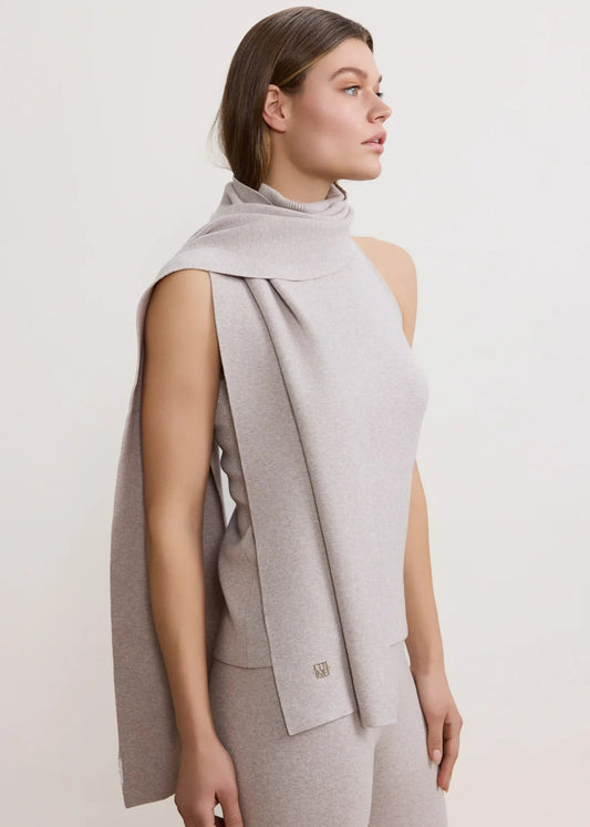 Woman wearing a light gray sleeveless vest over a matching top and pants on a white background